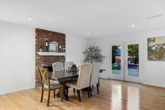 dining area featuring light wood finished floors, baseboards, visible vents, and french doors