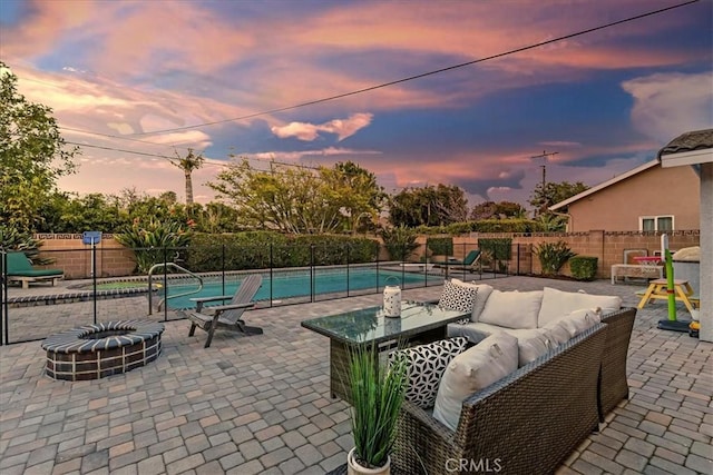 view of patio featuring a fenced backyard, a fenced in pool, and an outdoor living space with a fire pit