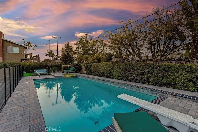 view of pool with a fenced in pool, a patio area, fence, and a diving board