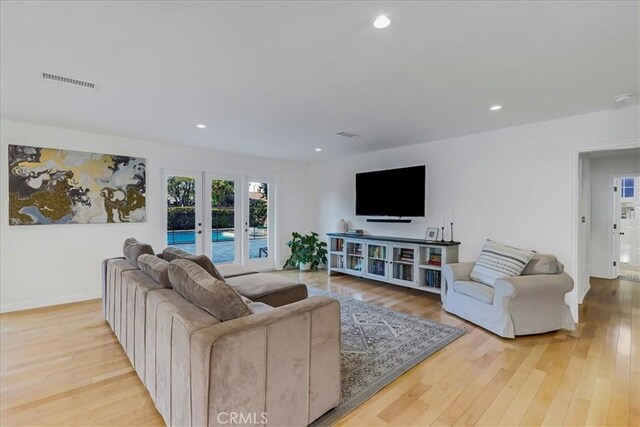 living area with baseboards, visible vents, hardwood / wood-style floors, french doors, and recessed lighting