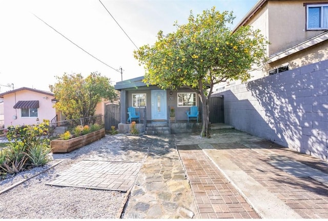 view of front of property with fence private yard, a patio area, and stucco siding