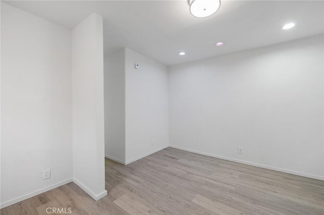 unfurnished room featuring baseboards, recessed lighting, and light wood-style floors