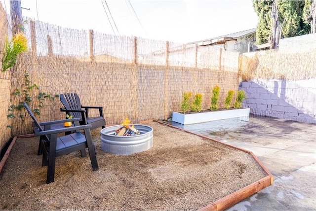 view of yard with a patio area, a fenced backyard, and a fire pit