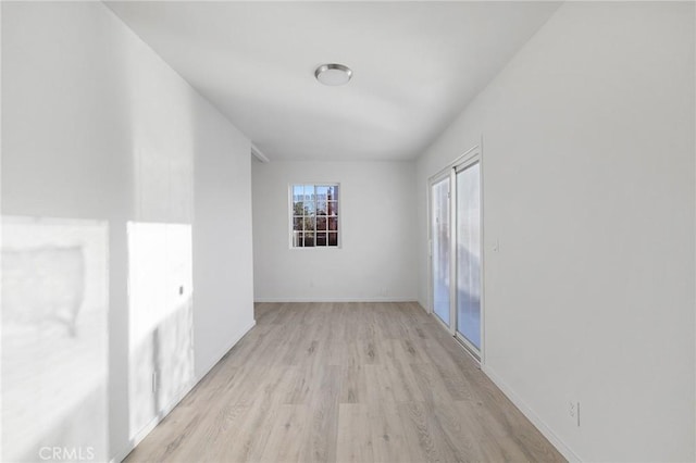 unfurnished room with light wood finished floors and baseboards