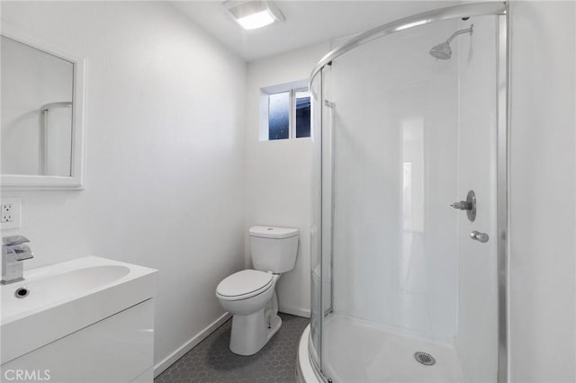 bathroom with toilet, a shower stall, vanity, and baseboards