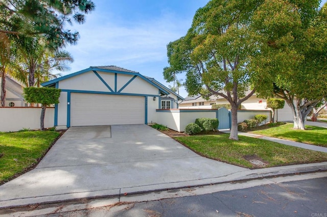 view of front of property featuring an attached garage, fence, concrete driveway, stucco siding, and a front yard