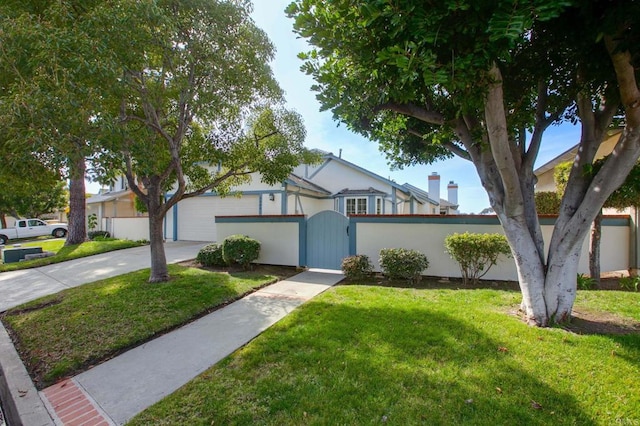 view of front of house with a front yard, a gate, and concrete driveway