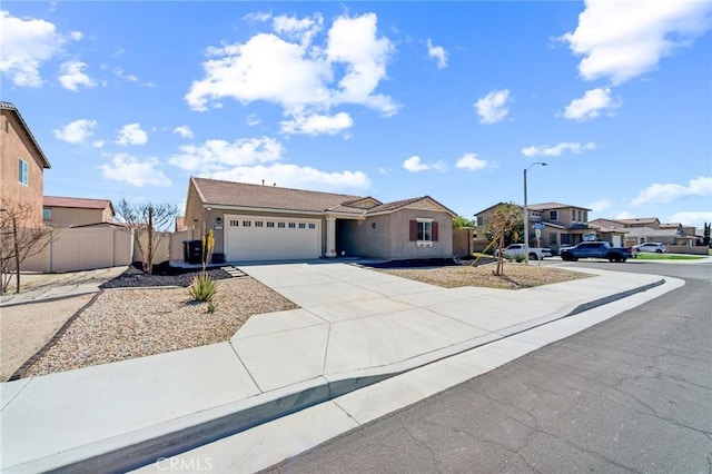 single story home featuring a residential view, concrete driveway, fence, and an attached garage