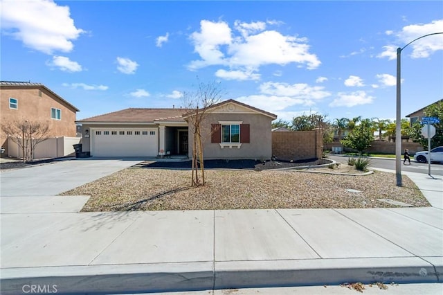 view of front of home featuring a garage, fence, concrete driveway, and stucco siding