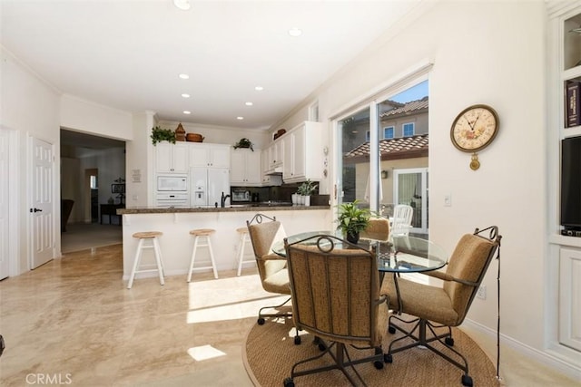 dining area with ornamental molding and recessed lighting