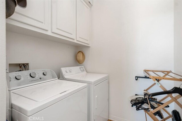 laundry room with baseboards, cabinet space, and washing machine and clothes dryer