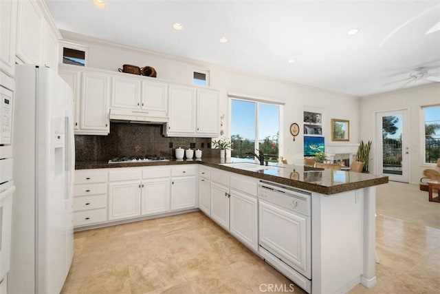 kitchen with paneled dishwasher, white cabinets, and a sink