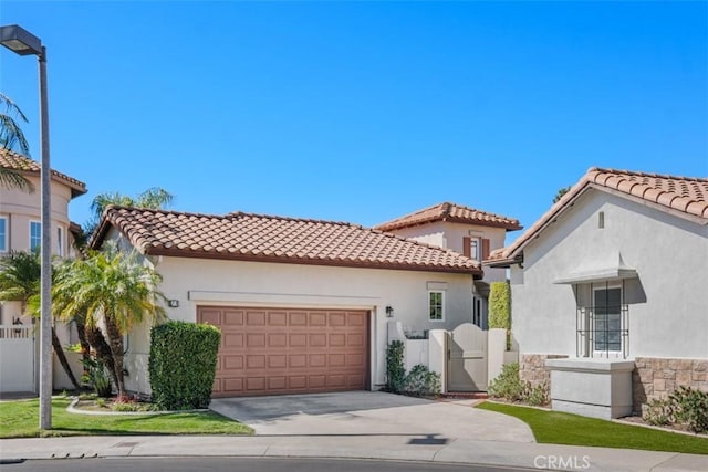 mediterranean / spanish-style home with a tiled roof, an attached garage, and stucco siding