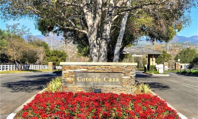 community / neighborhood sign featuring fence and a mountain view