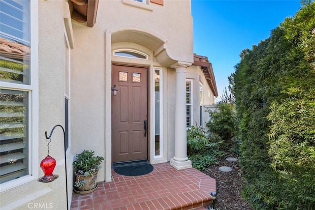 doorway to property featuring stucco siding