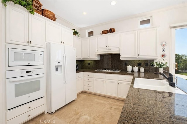 kitchen featuring under cabinet range hood, white appliances, a sink, white cabinets, and tile counters