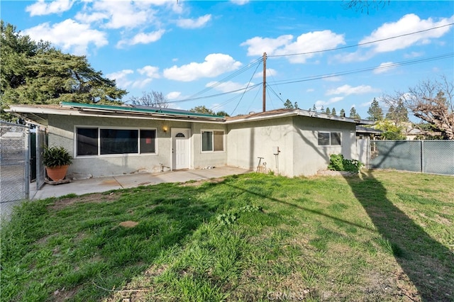 back of house with a patio area, a fenced backyard, a yard, and stucco siding