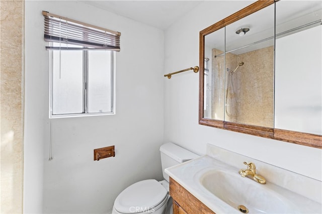 bathroom with toilet, a shower, vanity, and a wealth of natural light