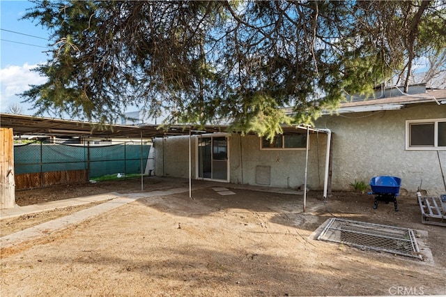 back of house with fence and stucco siding