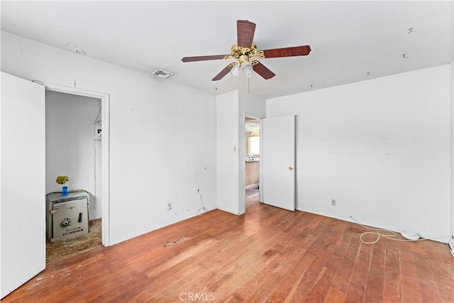 unfurnished bedroom with hardwood / wood-style flooring, visible vents, and a ceiling fan