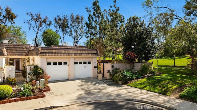 exterior space with mansard roof, a garage, concrete driveway, a gate, and a front yard