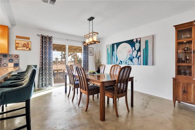 dining space featuring baseboards, finished concrete floors, and visible vents