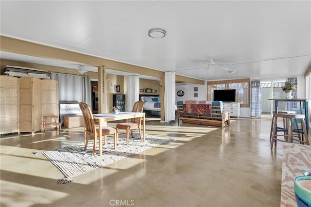 dining space featuring finished concrete floors and ceiling fan