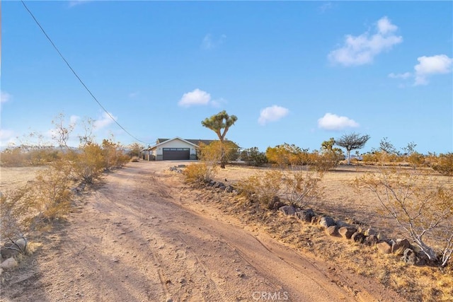 view of street with driveway and a rural view