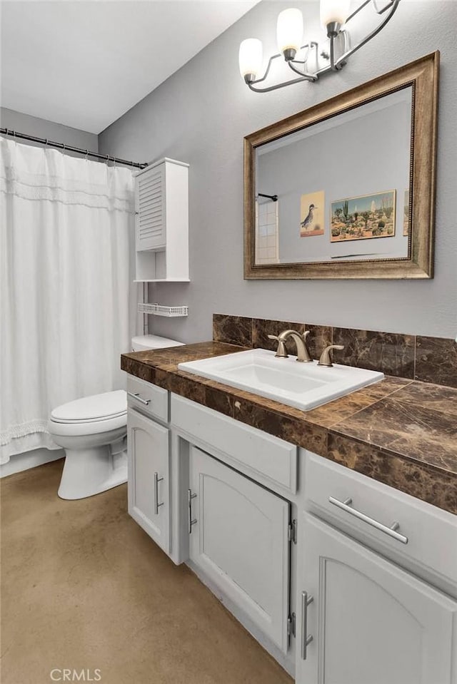 full bath with toilet, vanity, and a notable chandelier