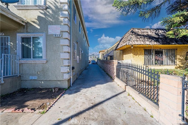 view of side of home featuring crawl space, fence, and stucco siding