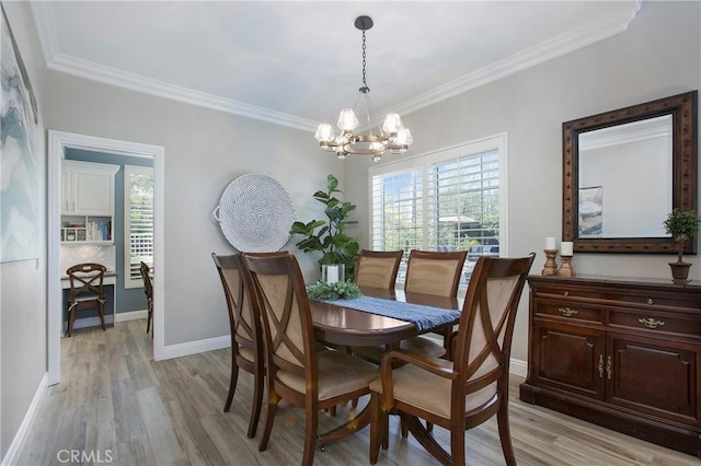 dining space featuring baseboards, ornamental molding, light wood-type flooring, and an inviting chandelier