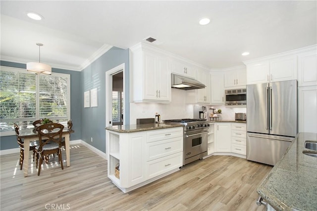 kitchen with premium appliances, white cabinets, under cabinet range hood, and dark stone countertops