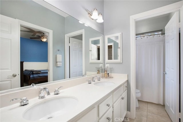 bathroom with toilet, tile patterned flooring, connected bathroom, and a sink