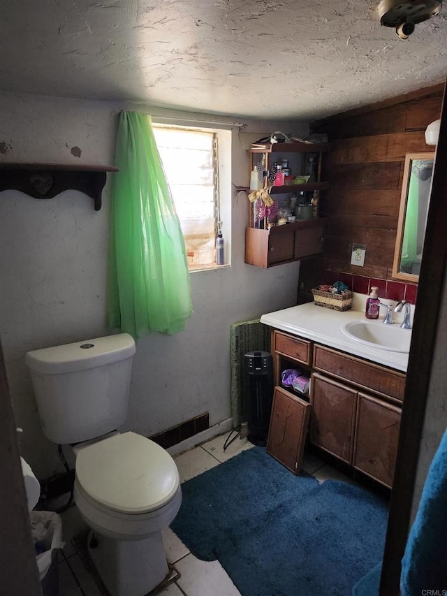 bathroom featuring a textured ceiling, lofted ceiling, toilet, vanity, and tile patterned floors