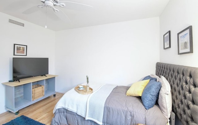 bedroom with a ceiling fan, visible vents, and light wood finished floors