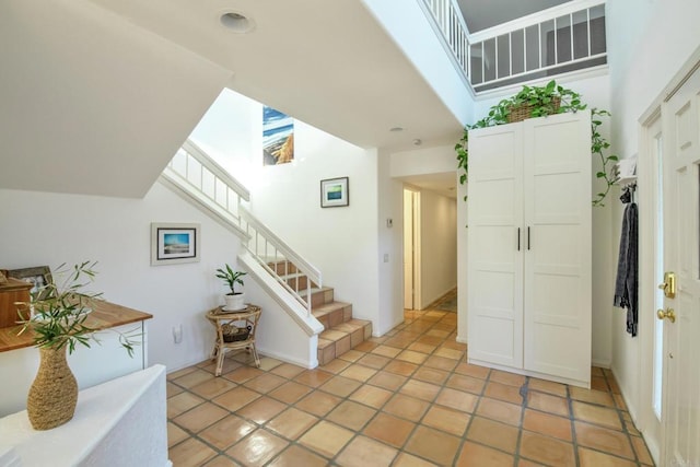 foyer with light tile patterned floors and stairs