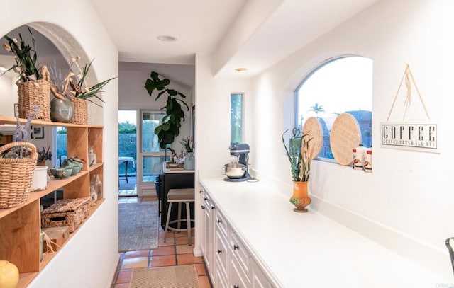 interior space featuring light countertops, light tile patterned flooring, and white cabinets