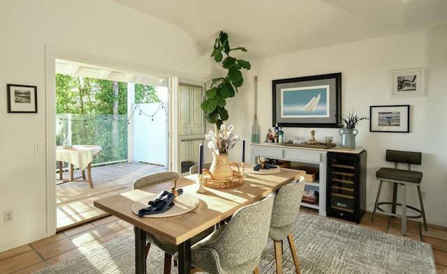 dining space featuring vaulted ceiling, wine cooler, and light tile patterned floors