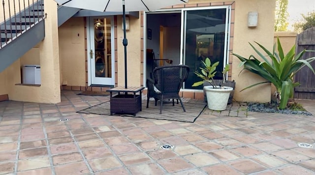 view of patio / terrace featuring fence and stairway