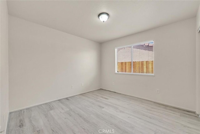 unfurnished room featuring light wood-type flooring and baseboards