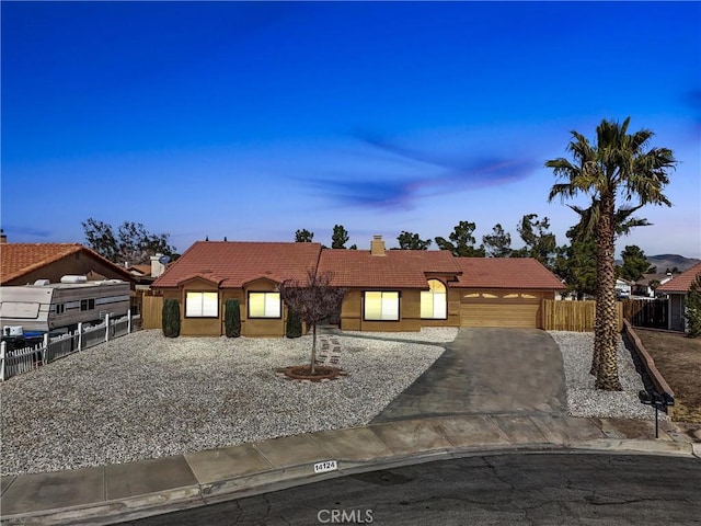 view of front of home featuring a garage, a tile roof, a chimney, and fence