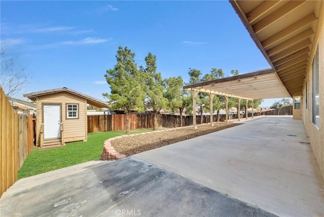 view of yard with entry steps, a patio area, an outdoor structure, and a fenced backyard