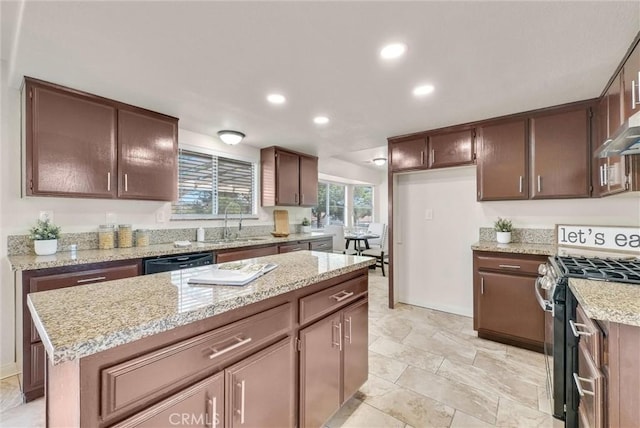 kitchen with dishwasher, stainless steel range with gas stovetop, a center island, light stone countertops, and a sink