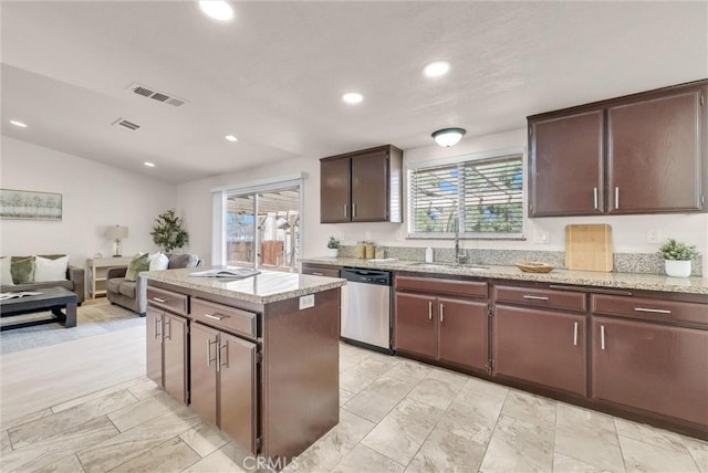 kitchen featuring dark brown cabinetry, visible vents, dishwasher, a kitchen island, and a sink