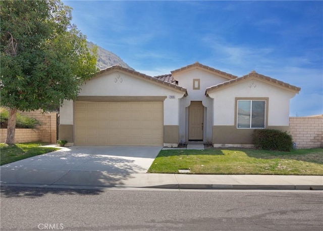 mediterranean / spanish-style home with an attached garage, fence, concrete driveway, stucco siding, and a front lawn