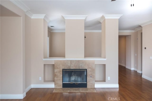 unfurnished living room featuring baseboards, crown molding, a tiled fireplace, and wood finished floors