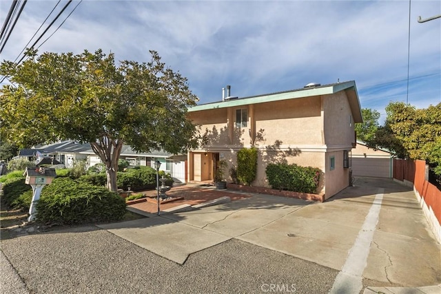 view of front facade with fence and stucco siding