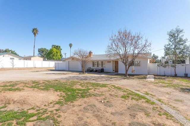 ranch-style home with a garage, fence, and concrete driveway