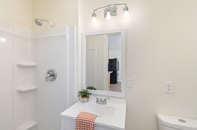 bathroom featuring toilet, walk in shower, and vanity