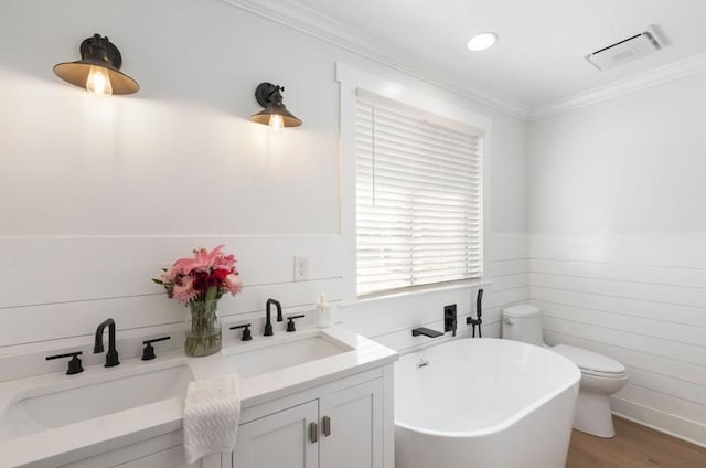 bathroom with ornamental molding, a soaking tub, a sink, and visible vents